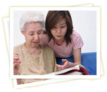 Caregiver and elderly woman looking at a book together